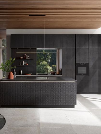 A full view of the Viennese wickerwork kitchen in black oak. The textured fronts create a stunning visual effect, especially when paired with a smooth, dark countertop.