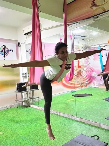 A classic aerial warrior pose. This demonstrates how we adapt traditional yoga postures for the hammock, adding an element of instability that enhances balance and core engagement.