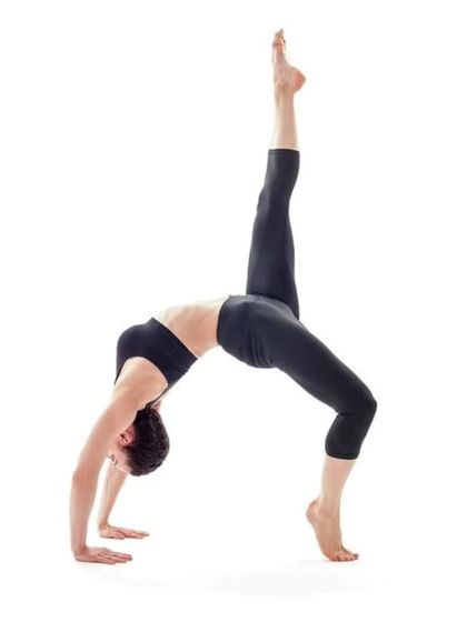 A demonstration of Eka Pada Urdhva Dhanurasana, or One-Legged Wheel Pose. This advanced backbend requires significant strength and flexibility.