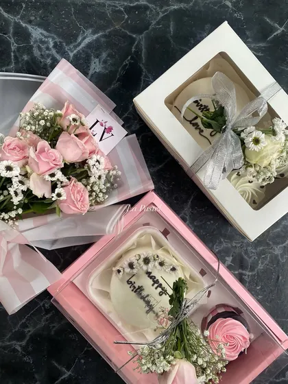This shows two of my hamper styles. One is a pink-themed birthday box and the other is a white and silver box, both with flowers.