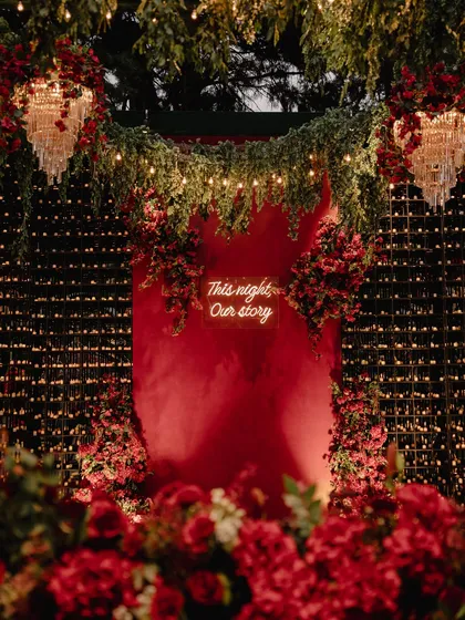 I believe in creating atmosphere that you can feel. For this sangeet, we painted the night in passionate reds, using a custom neon sign, a wall of candles, and untamed florals to build an immersive, electric energy for a night of celebration.