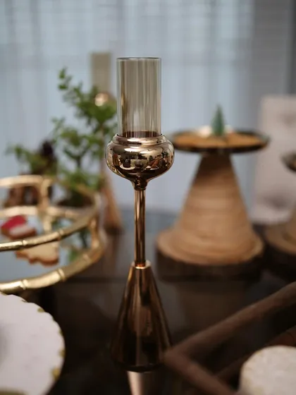 A single golden candle holder from our Vesper collection, adding a touch of height and warm light to a festive tablescape. Its sleek design complements a variety of decor styles.
