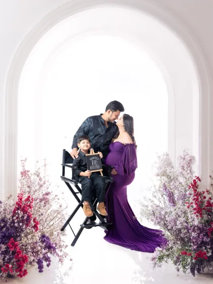 A beautiful family portrait celebrating the upcoming arrival. This sibling maternity session is set against a classic white arch in my studio, framed with delicate flowers to create a dreamy, light-filled atmosphere.