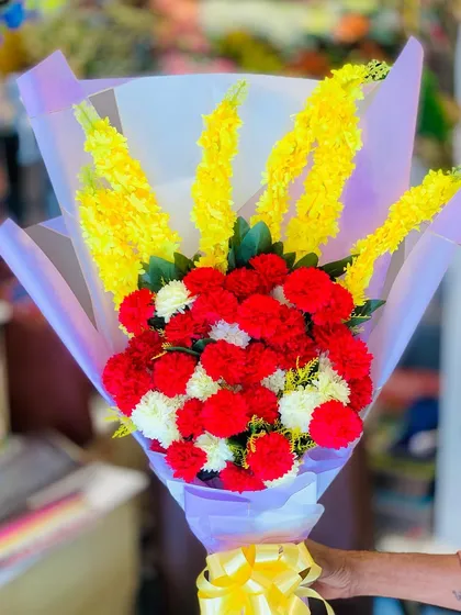 A close-up of the artificial flower bouquet, highlighting the realistic texture and color of the faux carnations.
