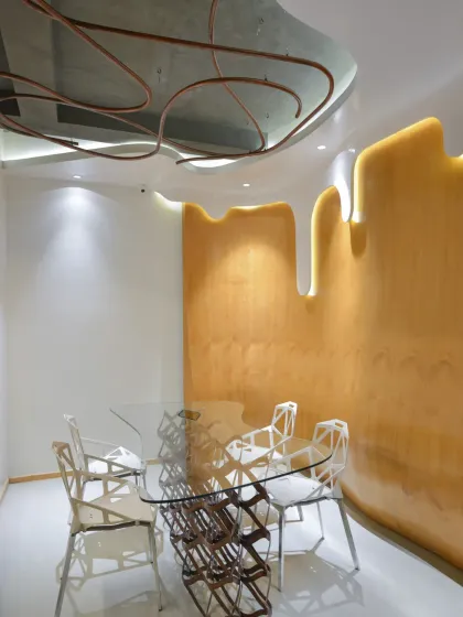 This meeting space in the AMG office showcases our experimental approach, with a fluid, backlit wall and a sculptural ceiling element. The design uses an interplay of light, art, and materials to create a space that is far from mundane.
