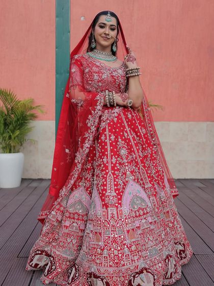Here is a full-length look at my traditional red bridal lehenga, paired with contrasting turquoise jewelry. The intricate embroidery tells a story, making it a true work of art for your wedding day.