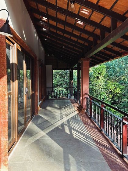 A glimpse of the wrap-around veranda at the Forest Haven, an ongoing project. The play of light and shadow from the timber roof structure onto the walkway creates a beautiful rhythm, with the lush forest just beyond the railing.