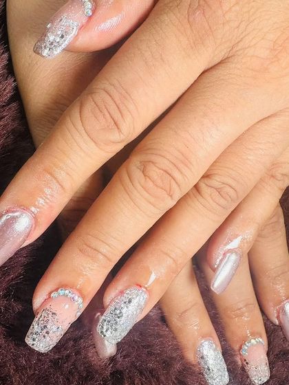 For the bride who loves to sparkle. This set combines pearly chrome nails with full-coverage silver glitter and rhinestone-lined cuticles.