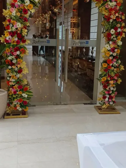 A vibrant floral arch I created for the entrance of the Radisson hotel. This grand welcome was designed for a corporate event using a mix of colorful roses, gerberas, and other seasonal flowers.