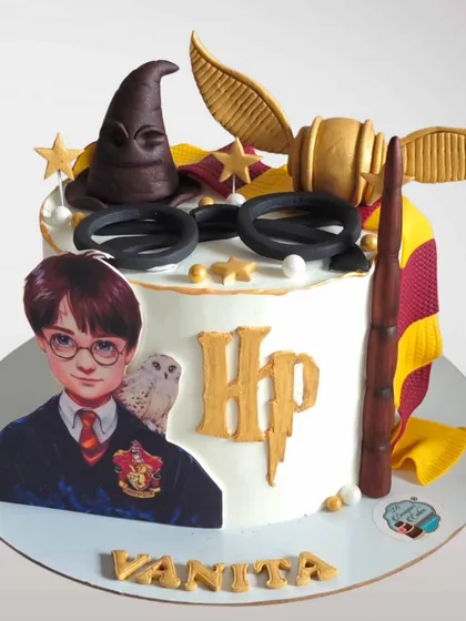 This Harry Potter cake features a printed image of Harry along with a fondant sorting hat, glasses, and wand. It's a great combination of 2D and 3D elements for a magical celebration.