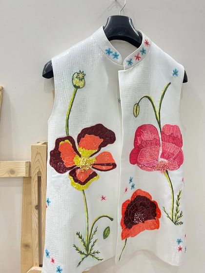 This piece combines hand-painting with hand-work. I painted these vibrant poppies on a white vest and then added sequin embellishments to the center of the flowers for an extra touch of sparkle.