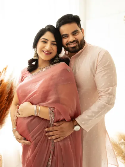 A beautiful portrait of a couple in traditional Indian attire. The soft pink saree and kurta create an elegant and culturally rich maternity photo.