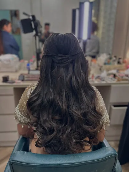 A simple and elegant half-updo with a twist, and the hair styled in very soft, natural waves.