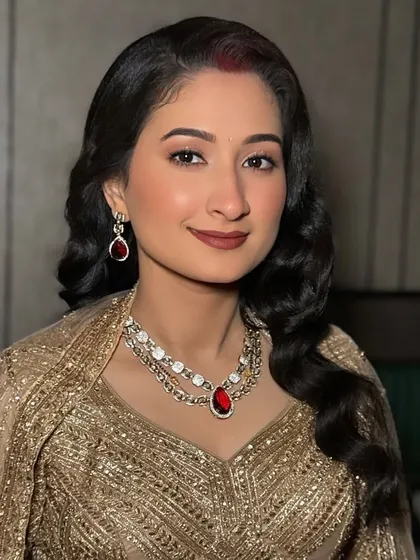 A beautiful portrait of the bride's reception look. The makeup is elegant and understated, letting her natural beauty and the stunning gold outfit shine.