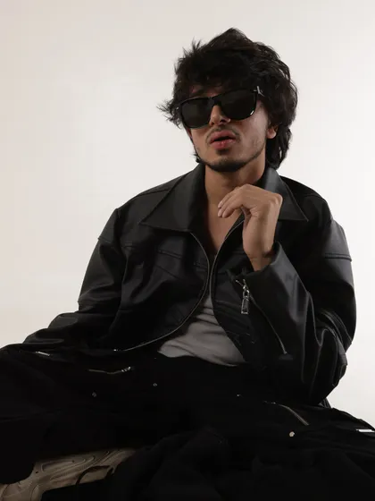 A seated portrait from my 2024 press shoot. This photo has a relaxed yet confident feel, showing my progress as an artist.