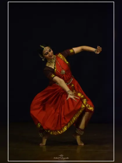 A dynamic pose from a performance in Pune, showing the fluid movement and strong lines that characterize the nritta, or pure dance, aspects of Bharatanatyam.