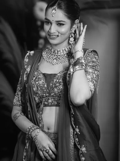 A candid, smiling black and white shot. Converting to monochrome brings attention to the bride's expression and the texture of the intricate beadwork on her outfit.