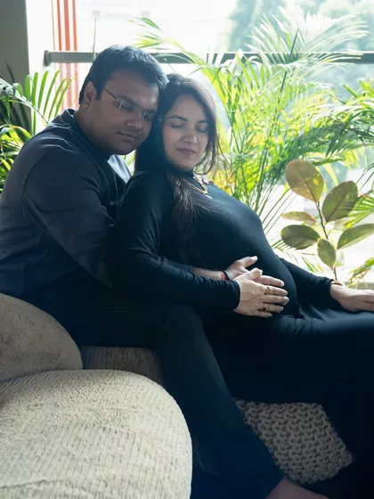 A peaceful moment on the couch. The natural light from the window and the surrounding plants create a serene and calm atmosphere for this couple's portrait.