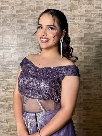 A full-length view of the stunning purple gown. The makeup complements the outfit perfectly.