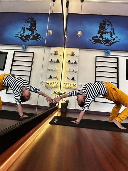 Happy New Year. A playful moment with my reflection, practicing a one-handed wheel pose in the studio.