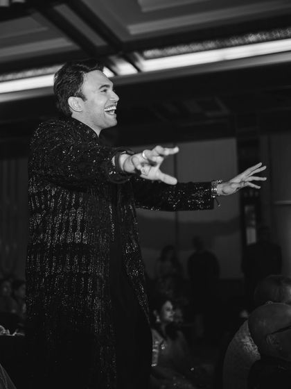 A dynamic black and white shot of the groom mid-performance, full of expression and energy.