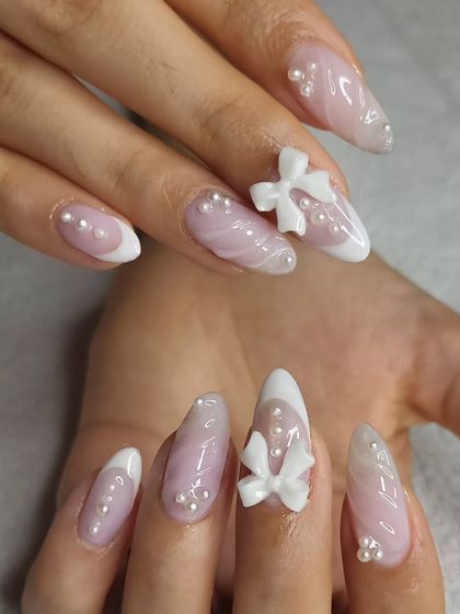 Another angle of these beautiful Korean-inspired nails. The combination of the soft ombre, the clean French tip, and the 3D bows with pearls is simply stunning.