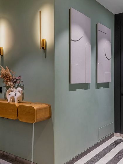 I love when clients say yes to black! Here, a black veneer door and mint green walls create a sophisticated entrance foyer, with custom art cleverly hiding the distribution board.