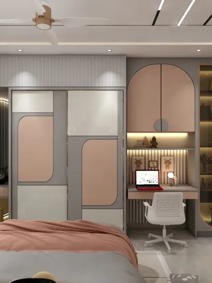 This view shows the functional side of the kids' room, with a full-wall wardrobe, a built-in study desk, and a stylish dressing table. The design uses a soft pink and grey palette.