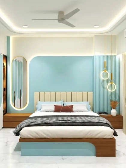 A bright and cheerful bedroom with a light blue accent wall and wooden furniture. The circular pendant lights and oval mirror add a soft, modern touch.