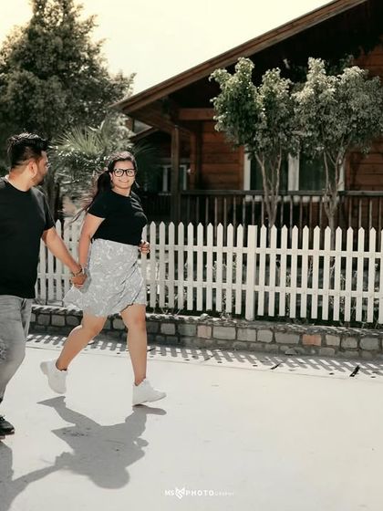 A fun, candid shot of a couple running and laughing together. This captures their playful energy and the joy of the moment.