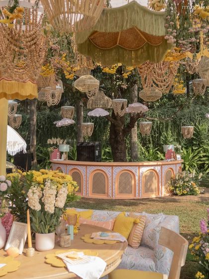 A view of the bar and lounge area at the 'Riverside Brunch', where dozens of wicker and fabric lanterns hang from the trees, creating a magical canopy.