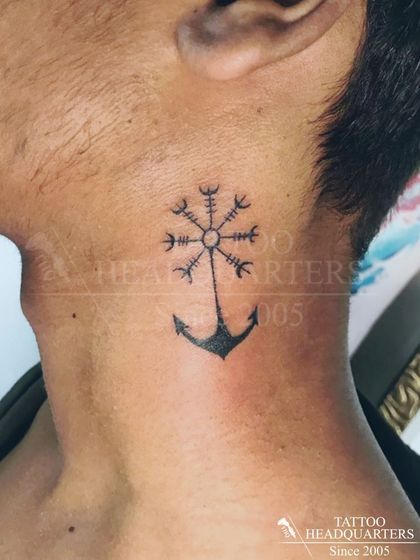 A minimalist anchor combined with a Vegvisir (Norse compass) symbol on the neck, representing guidance and stability.