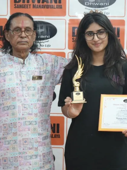 A senior guru with a student and her award.