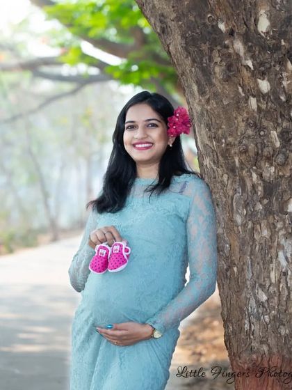 A classic maternity pose with a pair of tiny pink shoes. The mom-to-be's happy smile says it all as she anticipates the arrival of her daughter.