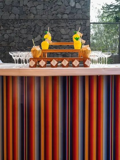 The colorful, striped bar at the carnival-themed wedding event, serving refreshing drinks to match the vibrant mood.