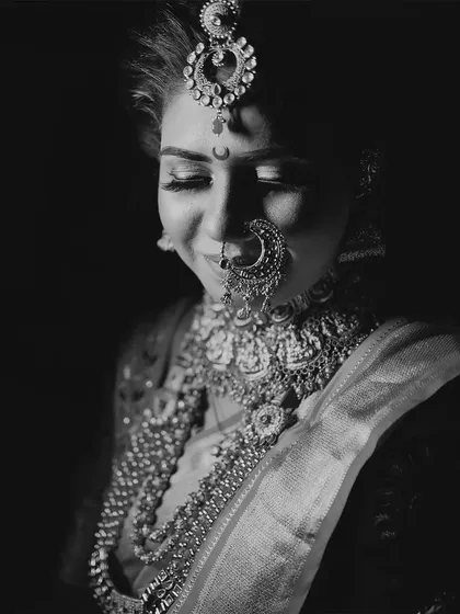 A classic black and white close-up of a bride, focusing on her intricate jewelry and serene expression.