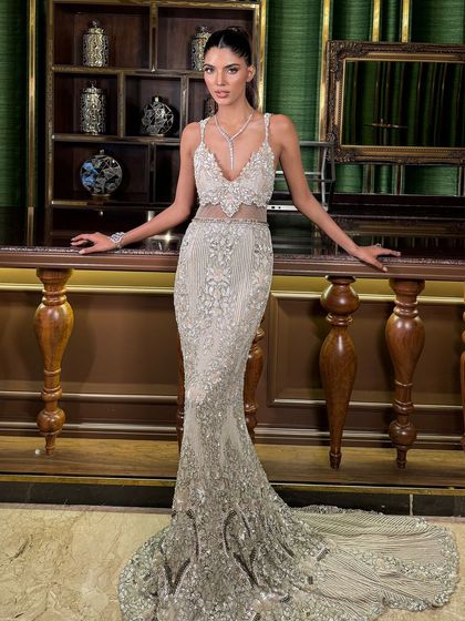 The full-length view, showing how the sleek ponytail creates a clean, elongated line that complements the mermaid-style gown.