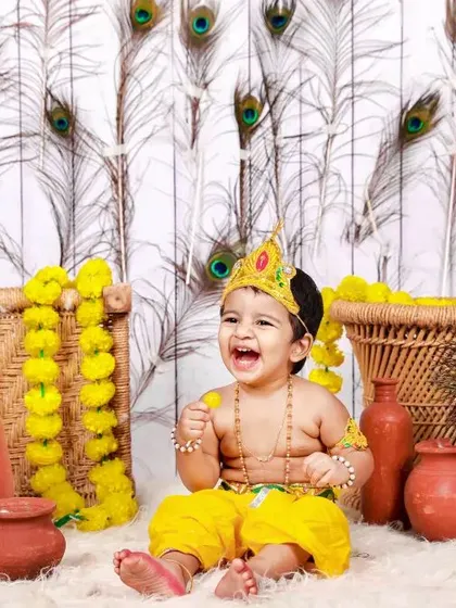 The pure joy of a festival. This little one, dressed as Krishna for a Janmashtami mini session, is all smiles surrounded by a vibrant setup of marigolds and peacock feathers. These themed shoots are a wonderful way to celebrate traditions.
