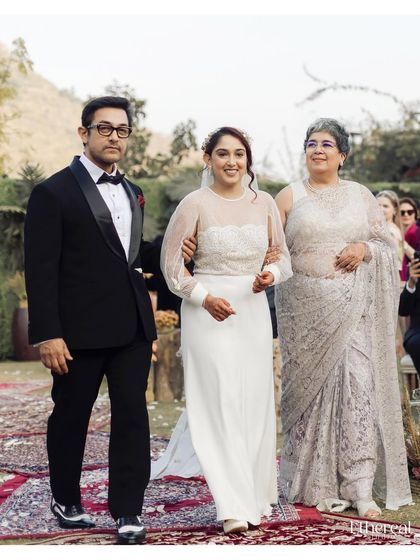 The bride being walked down the aisle by both her mother and father. This image is a powerful representation of family, support, and the beginning of a new chapter.