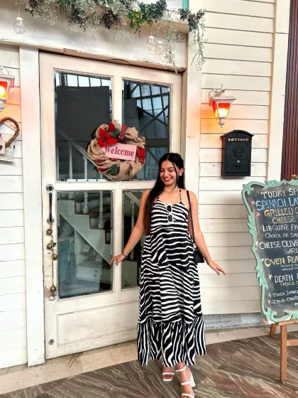 A guest poses happily at our entrance, ready to step inside for an experience filled with French flair and delicious food.