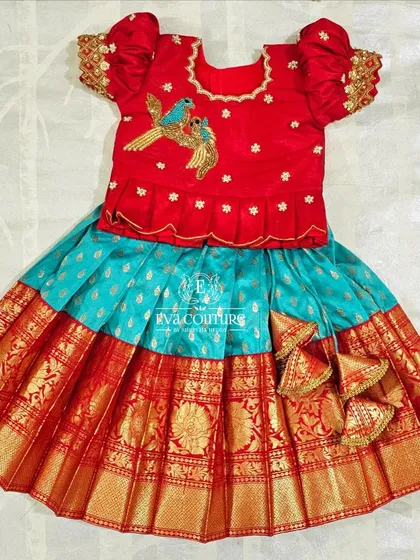 A red pattu pavadai blouse with two embroidered blue birds. This playful detail is perfect for a child's outfit.