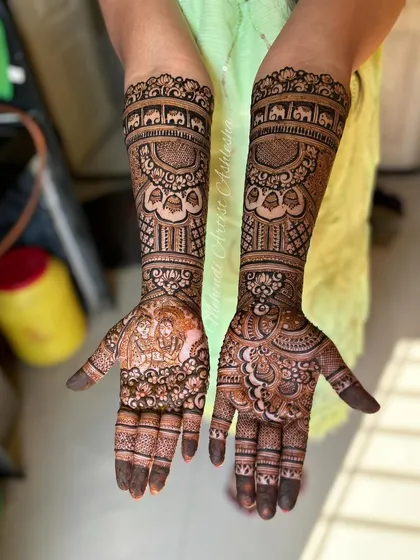 Another angle of the Radha Krishna bridal mehendi. This view shows the full composition, from the detailed figures on the palms to the traditional motifs on the arms.