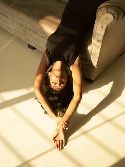 A creative shot using natural light and shadows. The model is positioned to catch the morning sun, creating a beautiful pattern on the floor and a warm, peaceful mood.