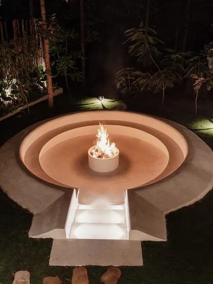 I designed this sunken fire pit as a central gathering spot for cool evenings. The circular, tiered design creates an intimate setting for conversation, surrounded by the lush landscape of the property.