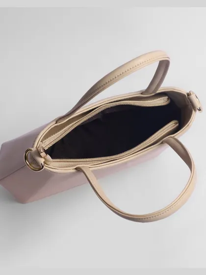 An overhead shot of an open beige purse, giving a clear view of its internal layout.