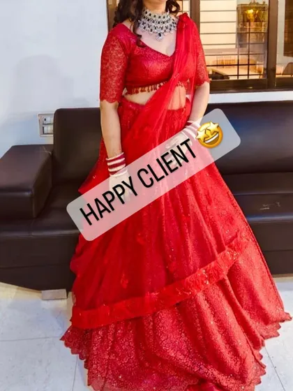 A client looking radiant in a bright red layered lehenga, perfect for a wedding or festive celebration.