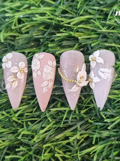 Elegance in white and pink. This beautiful set, created by one of our students, features 3D white flowers on a glittery base with delicate gold bead accents.