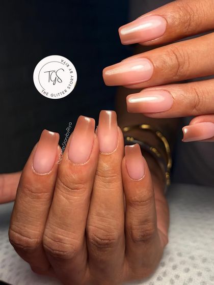 A beautiful example of a 'glass nail' effect. This features long, square-shaped extensions with a transparent brown ombre, creating a chic and modern look.