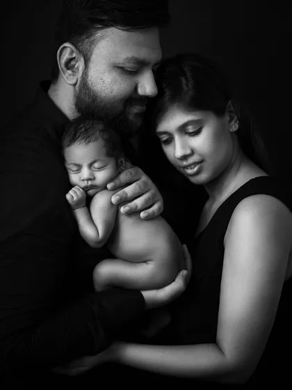 The complete family, wrapped in shadows and love. This intimate portrait focuses on their connection, a private world of three.