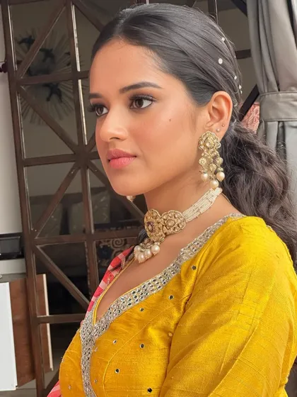 A portrait from a sundowner Haldi. The makeup is glamorous yet fresh, with a focus on defined eyes and radiant skin that catches the golden hour light perfectly.